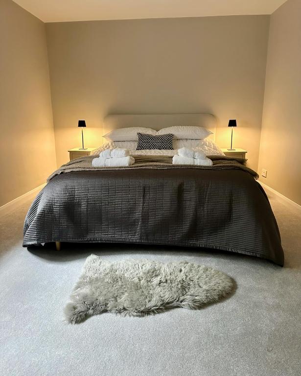 a bedroom with a bed with a furry rug on the floor at Castle View Apartments - The Hideout in Kendal