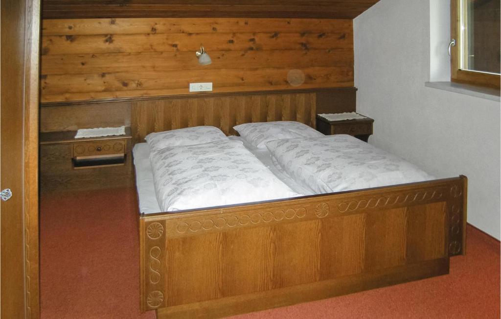 łóżko w pokoju z drewnianym zagłówkiem w obiekcie Ansprechende Ferienwohnung w mieście Brixlegg