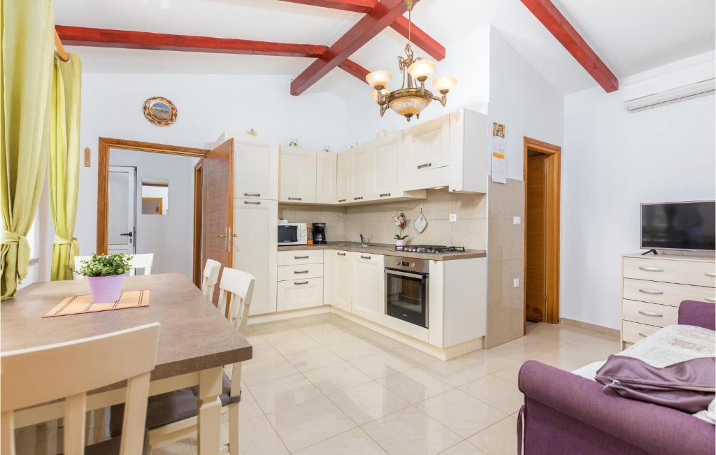 kuchnia z białymi szafkami i stołem w obiekcie Amazing Home In Rovinj With Kitchen w Rovinj