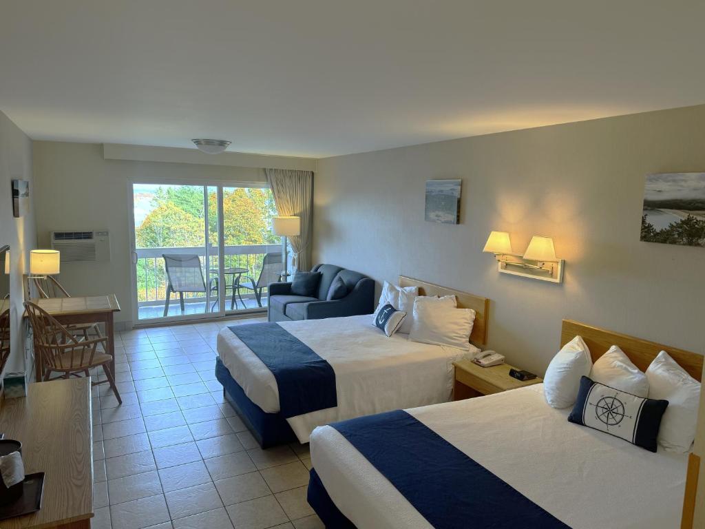 a hotel room with two beds and a balcony at Atlantic Eyrie Lodge in Bar Harbor