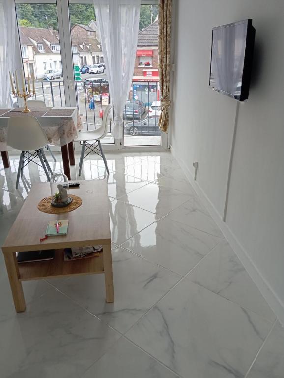 - un salon avec un sol en marbre, une table et une télévision dans l'établissement Flosoleil, à Beauvais