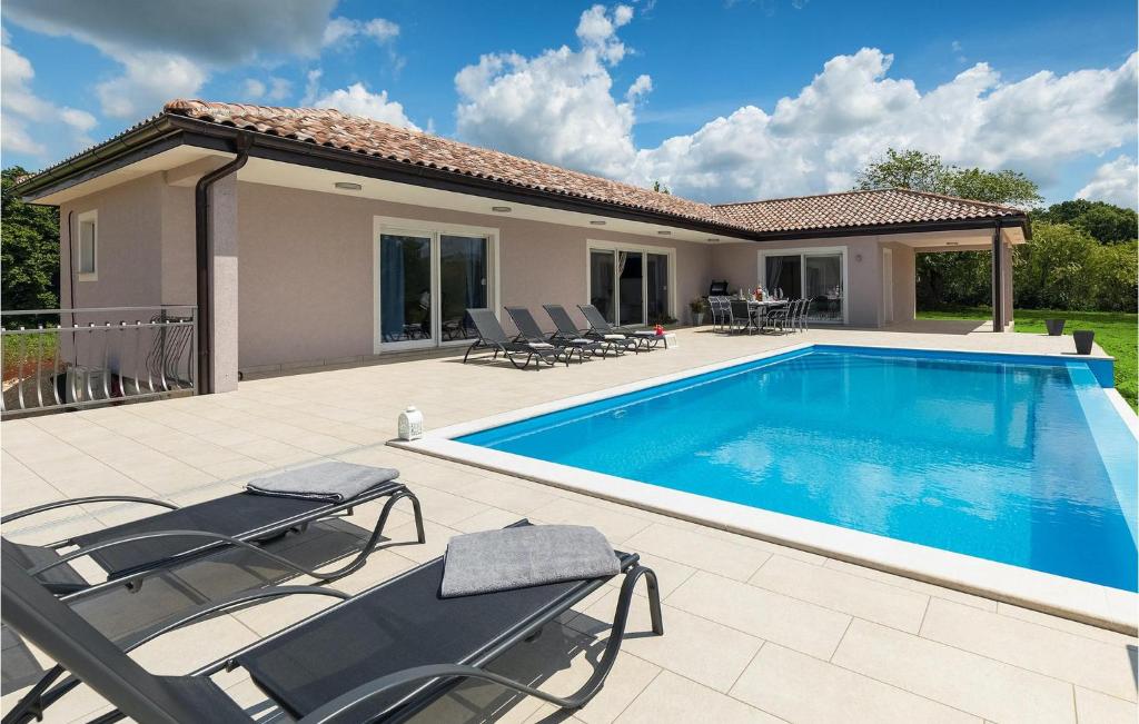 a swimming pool with chairs and a house at Villa Heaven in Heki