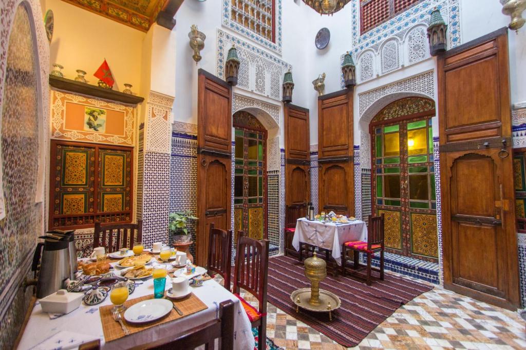 una sala da pranzo con tavolo in un edificio di Casa Aya Medina a Fes