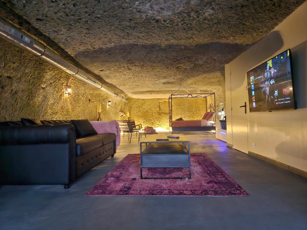 un soggiorno con un divano e un tavolo di Troglodyte Loft a Saint-Étienne-de-Chigny