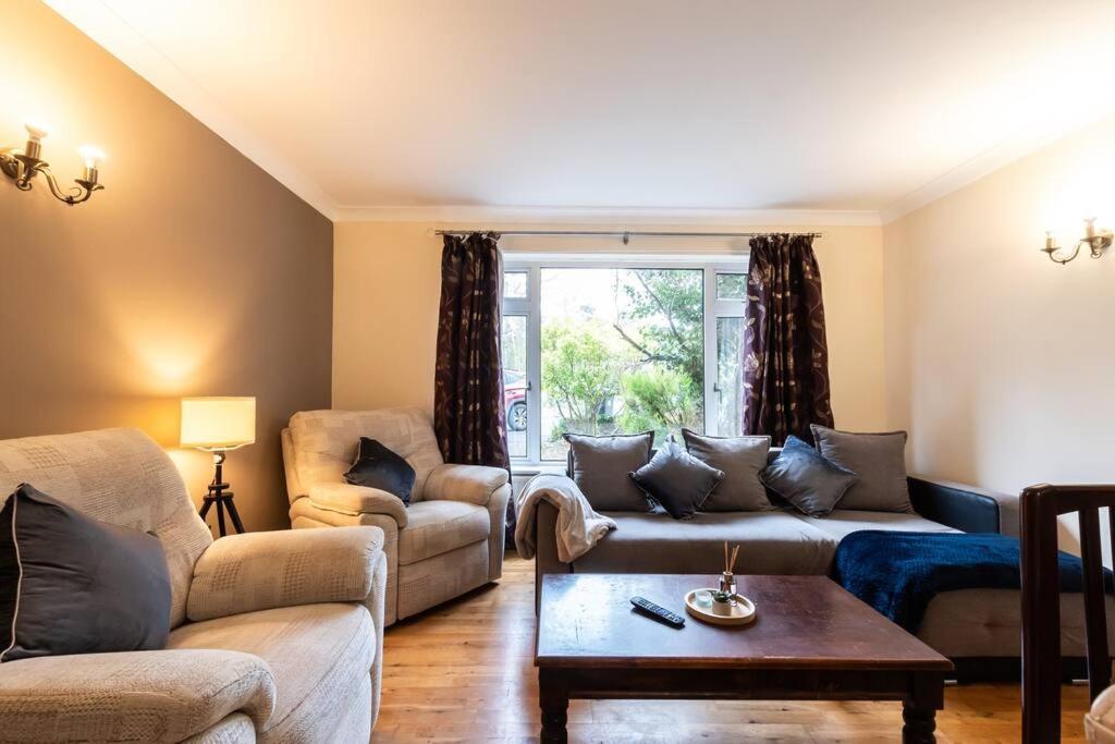 a living room with a couch and a table at Spacious and Comfortable Home in Chandlers Ford