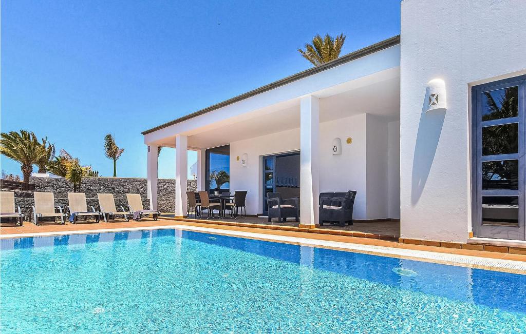 una piscina frente a una casa en Amazing Home In Playa Blanca With Sauna, en Playa Blanca