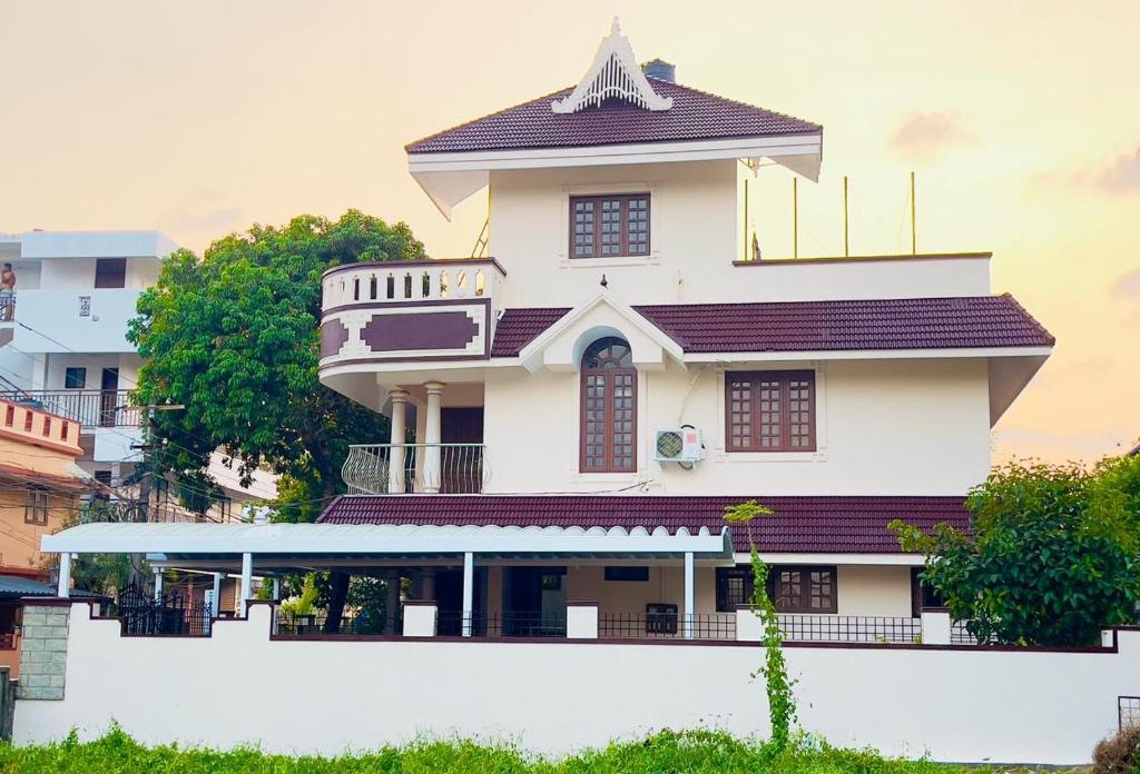 a tall white building with a balcony on top of it at Mangosteen villa in Ernakulam