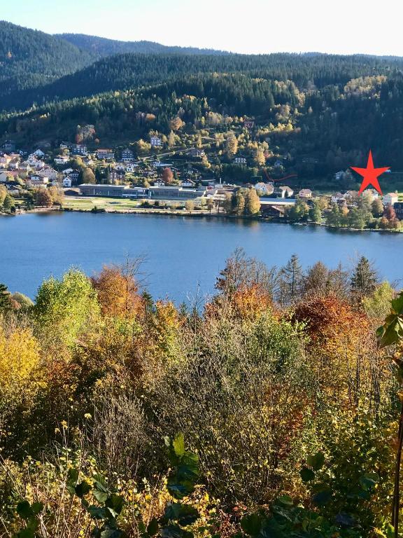 - une vue sur un lac avec une ville et une étoile rouge dans l'établissement GERARDMER Rés Aubépine 100m du lac Appt 4 personnes, à Gérardmer