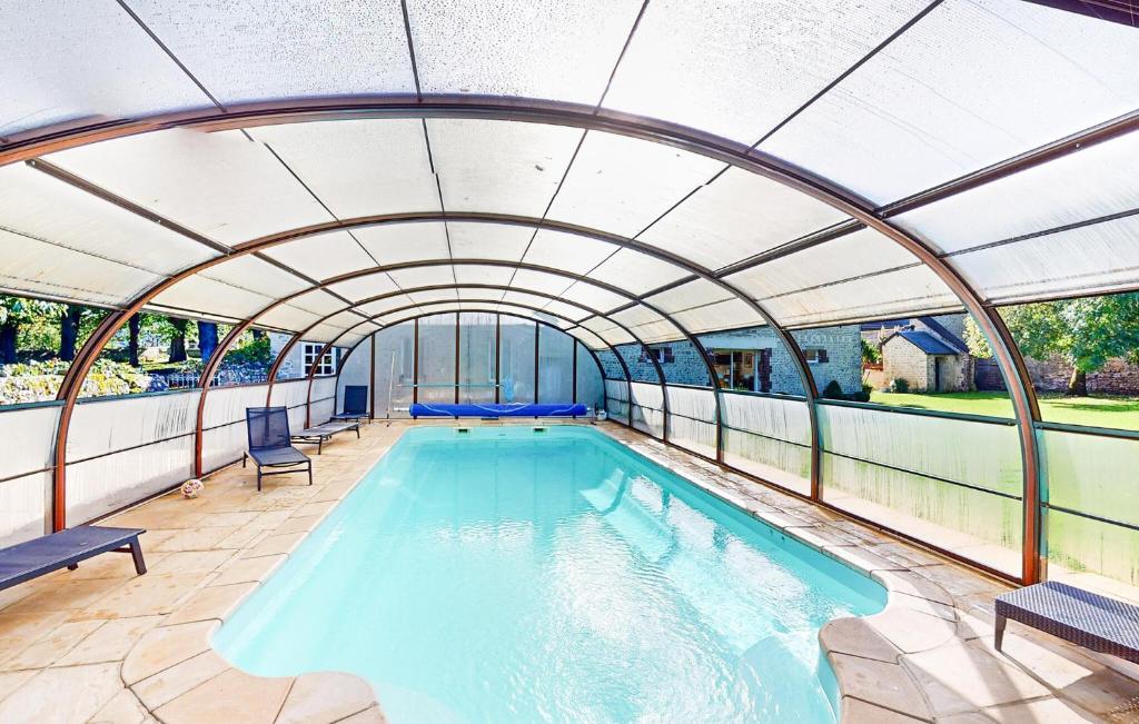 an indoor swimming pool with an arched ceiling at Awesome Home In Rubercy With Sauna in Rubercy