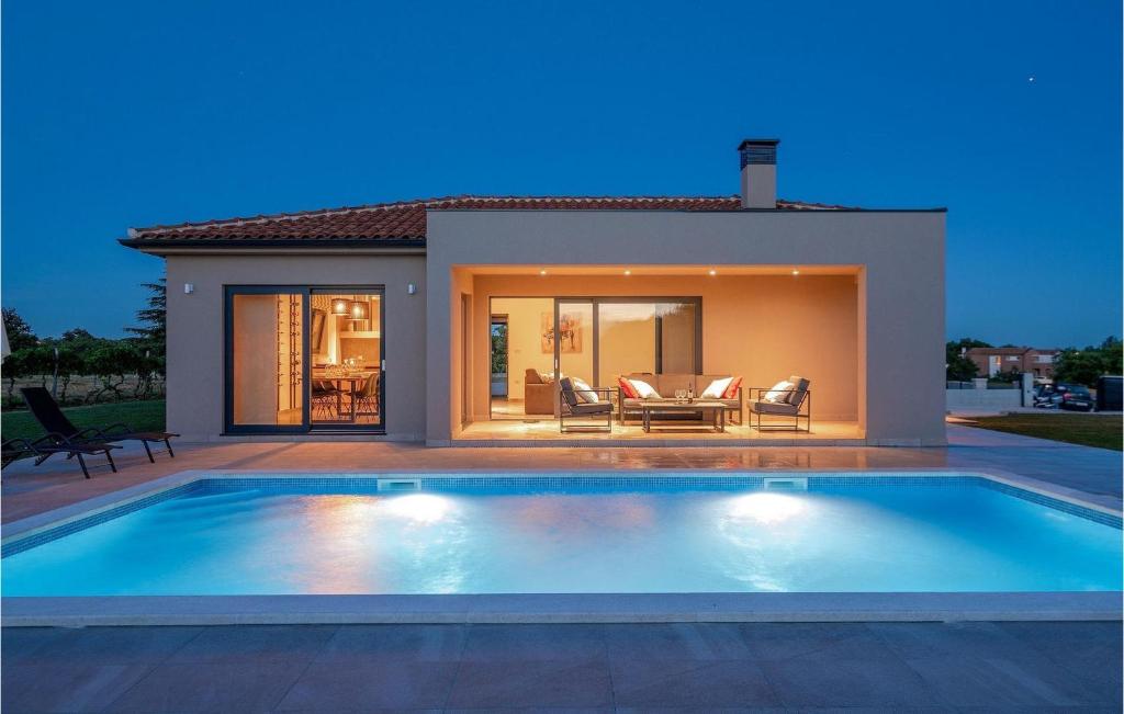 een zwembad voor een huis bij Villa Vitis Vitae in Peresiji