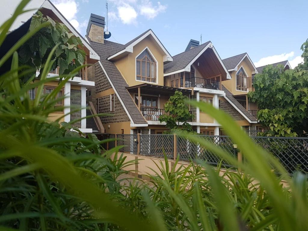 a large house with green plants in front of it at Asyana Gardens in Nairobi