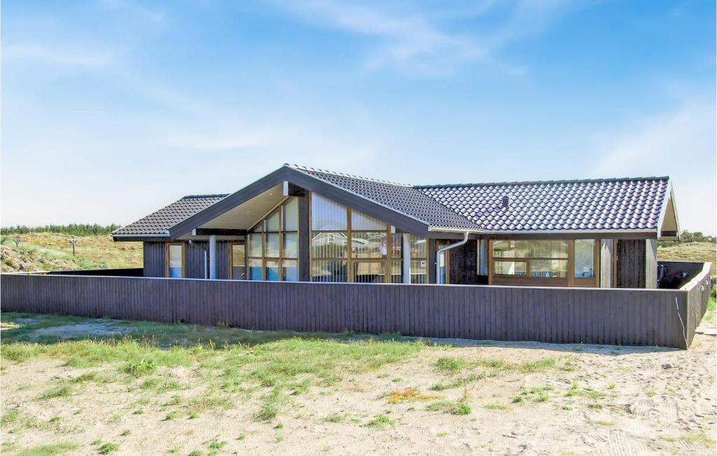 a house on the beach with a black roof at Holiday Home Arvidvej Hvide Sande Denm in Bjerregård