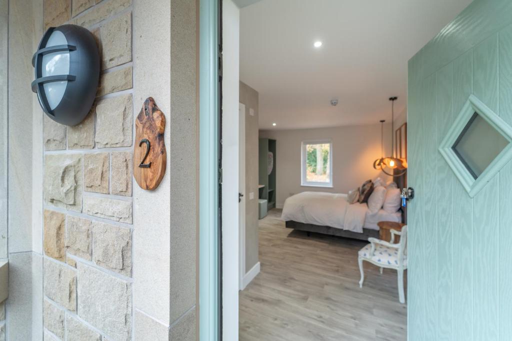 a room with a bedroom with a bed and a door at Bankton Rooms & Lodges in Livingston