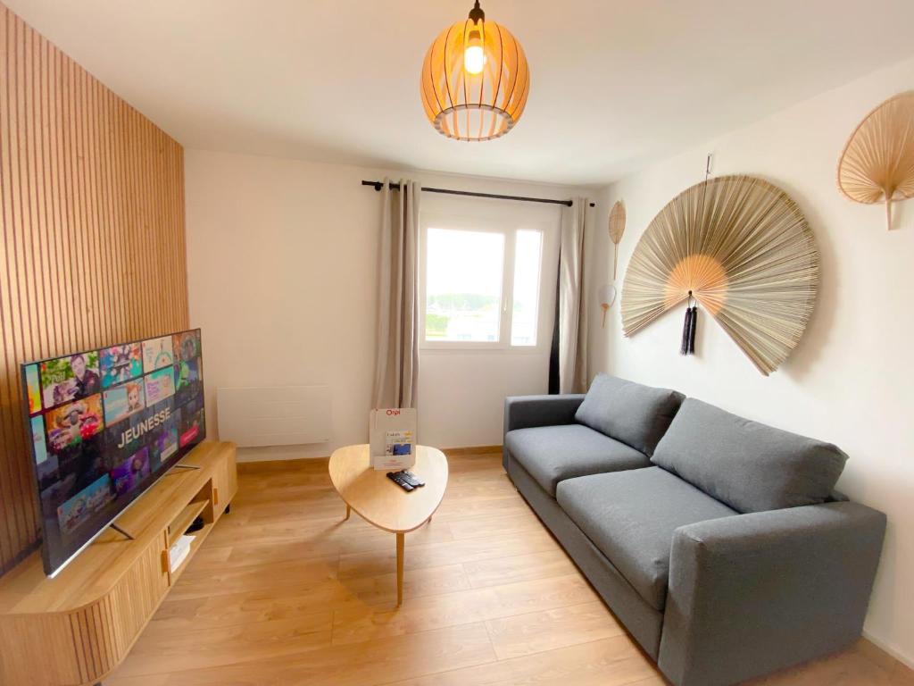 un salon avec un canapé et une télévision dans l'établissement Le Côte d'Opale, à Calais