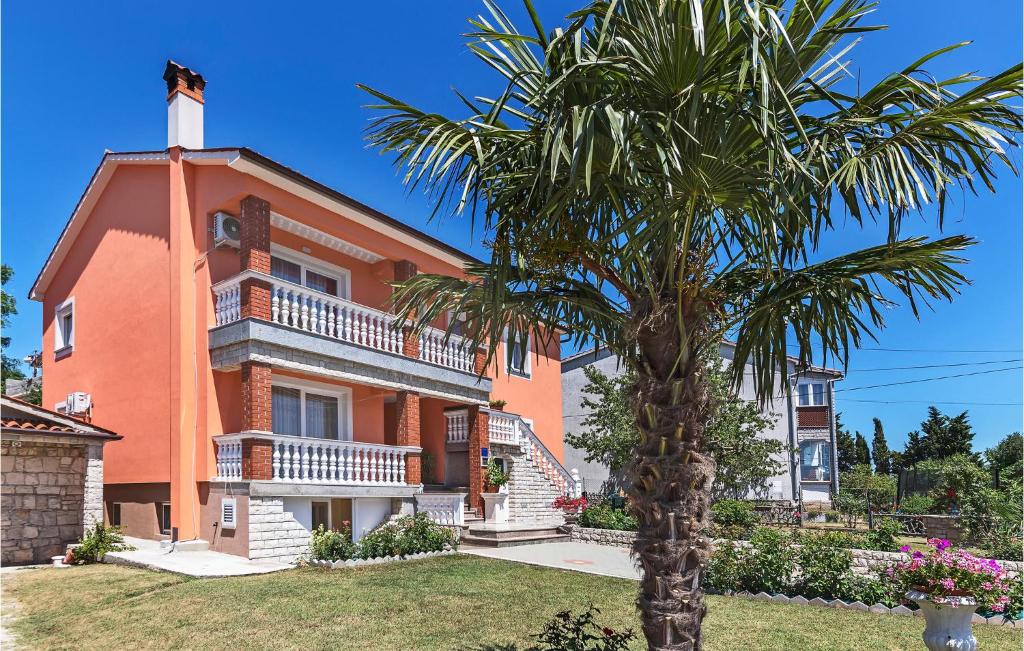 una casa de naranjos con una palmera delante de ella en 1 Bedroom Stunning Apartment In Labin, en Labin