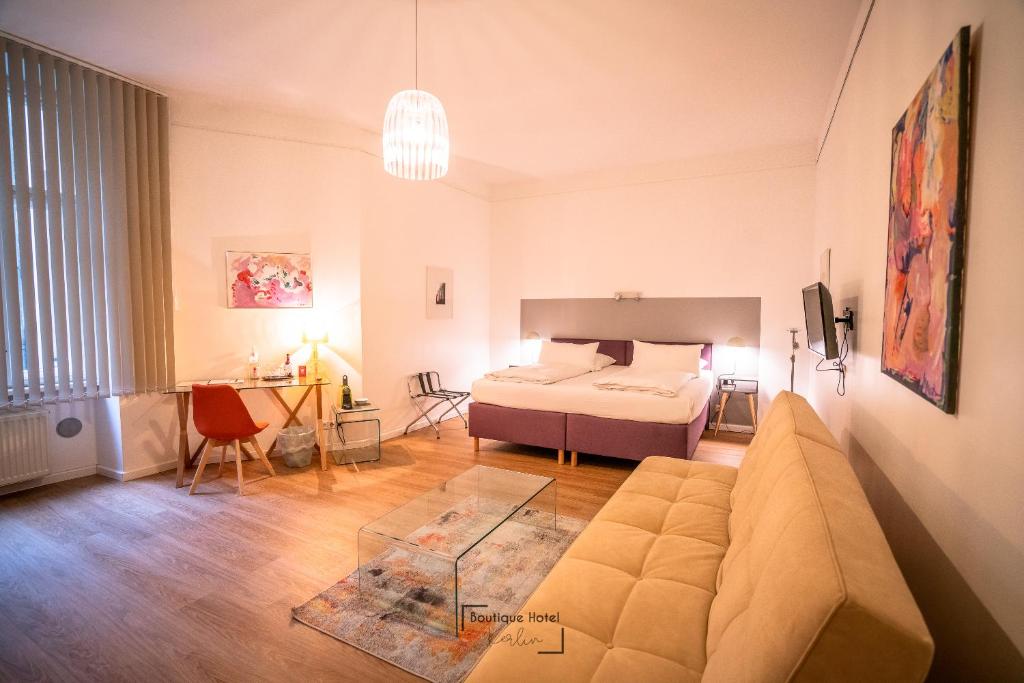een woonkamer met een bank en een bed bij Boutique Hotel Kerlin in Berlijn