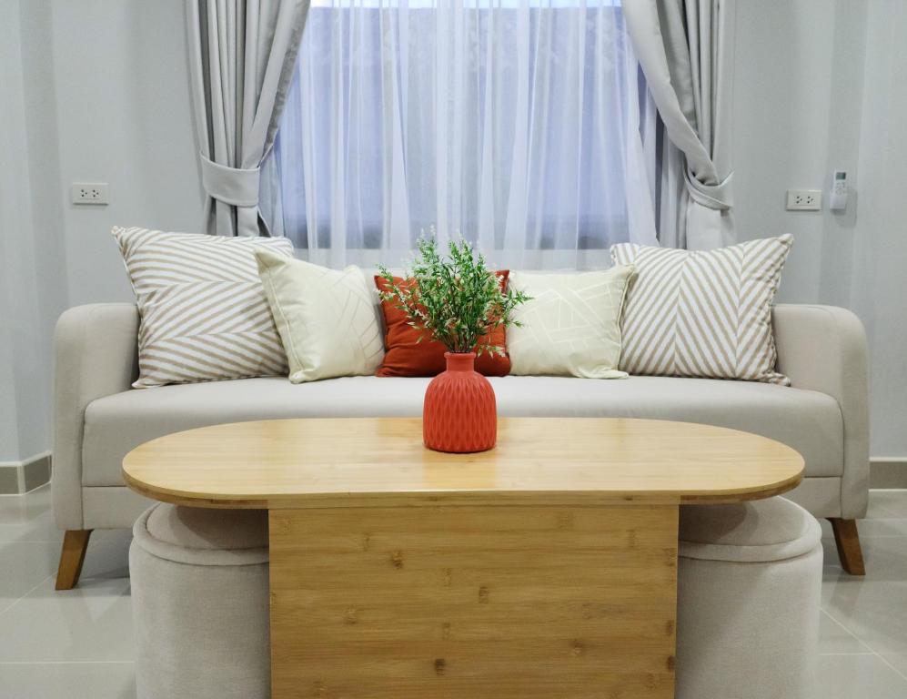 ein Wohnzimmer mit Sofa und Tisch in der Unterkunft Calm & Cozy Vacation House in Rawai Beach