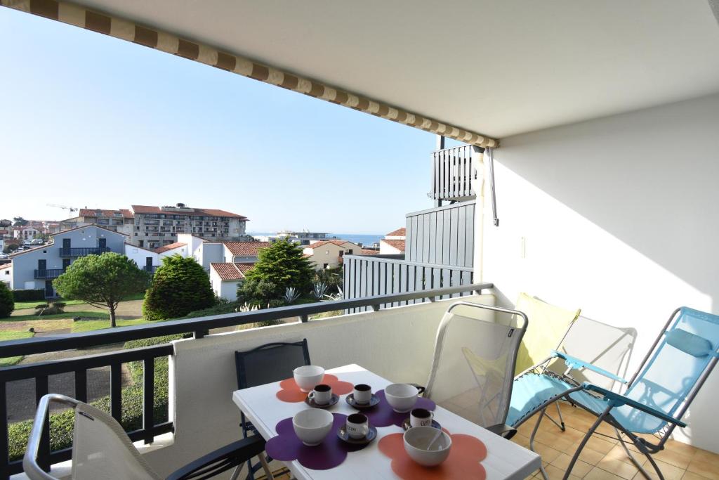 un balcon avec une table et des chaises et une vue dans l'établissement Résidence Les Terrasses de Notre Dame, bel appartement avec vue sur l'entrée du port, à Capbreton