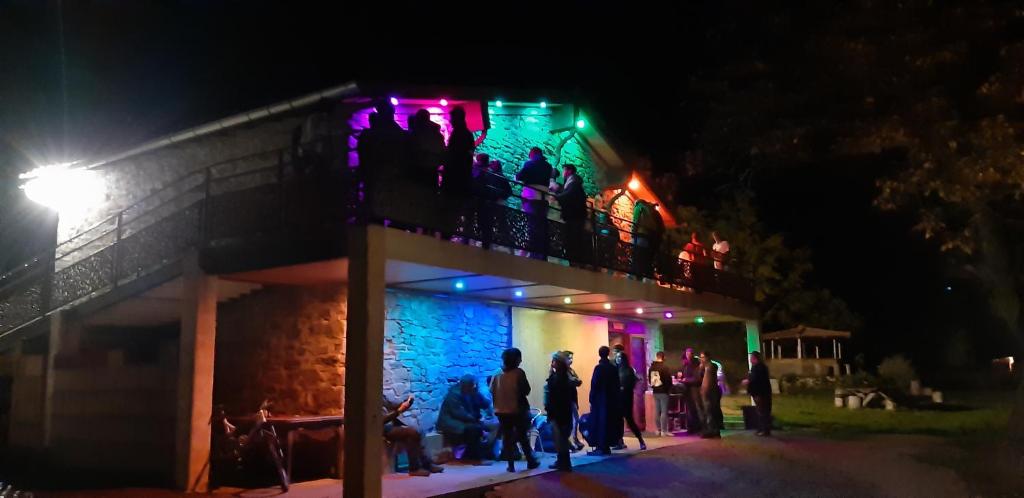 un groupe de personnes debout sur un balcon la nuit dans l'établissement La Grange du Soleil, à Rouvenac