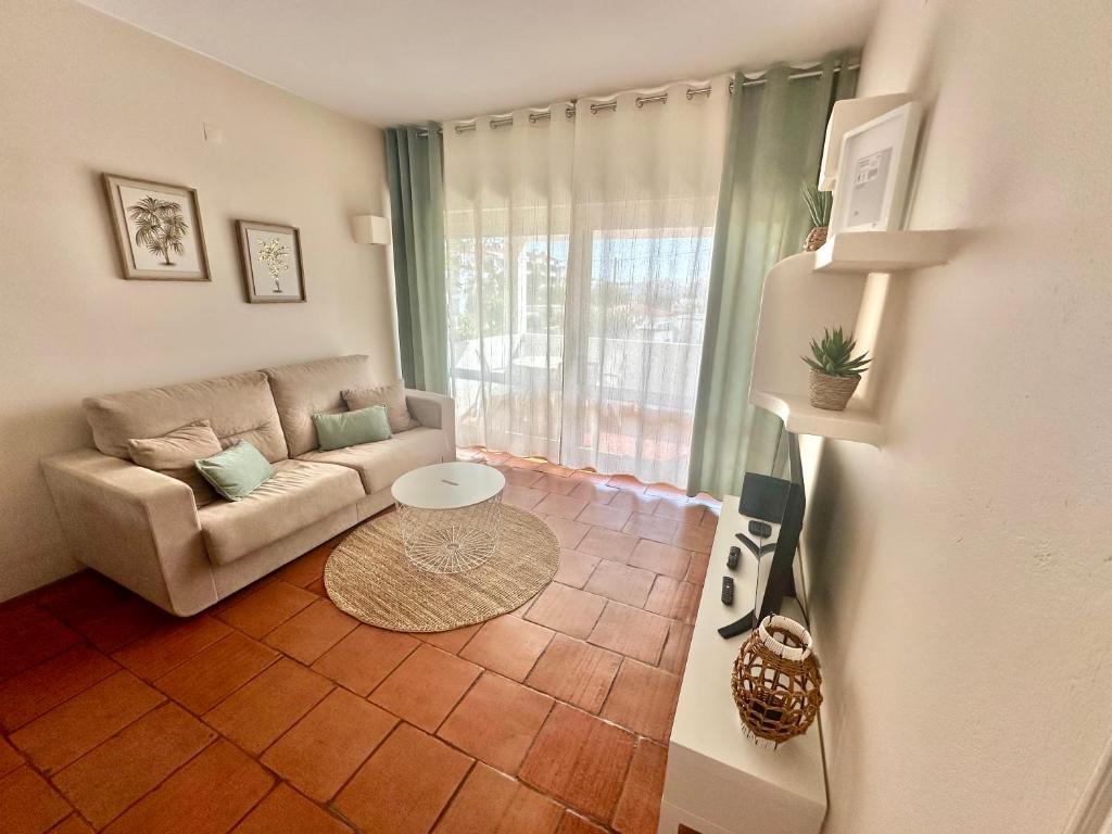 a living room with a couch and a table at Solar Home appartement T2 in Albufeira