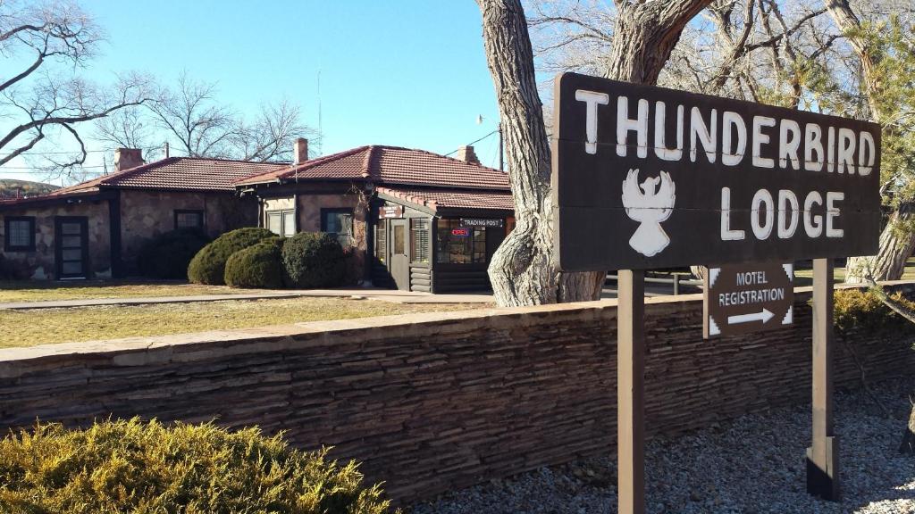 un panneau devant une maison avec un aumbledore dans l'établissement Thunderbird Lodge, à Chinle