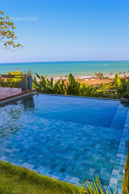 a swimming pool with a view of the beach at Casa Edom - Maceió in Maceió