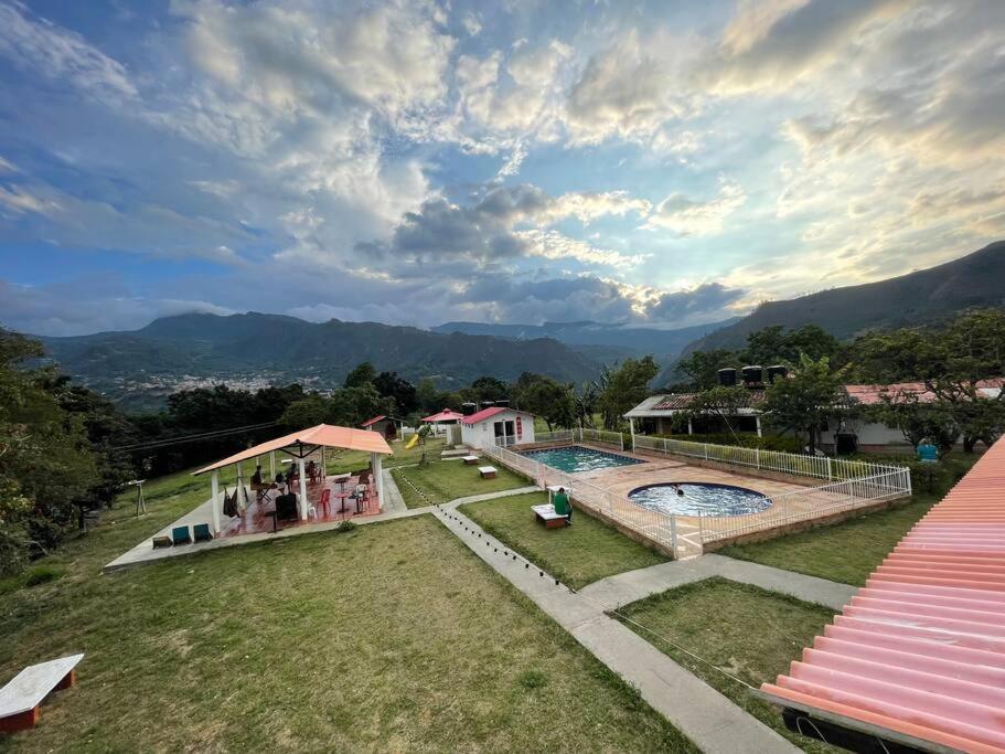 a resort with a pool and mountains in the background at Finca Turística El Porvenir in Cáqueza