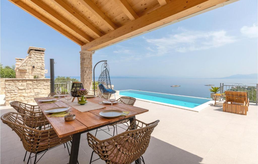 un patio con tavolo e sedie e una piscina di 3 Bedroom Nice Home In Blato a Blato