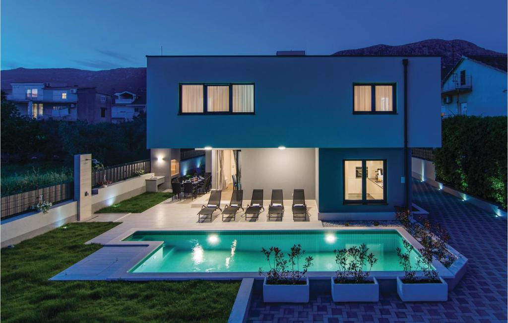 ein Haus mit einem Swimmingpool davor in der Unterkunft Five-Bedroom Holiday Home In Kastel Kambelovac in Kaštela