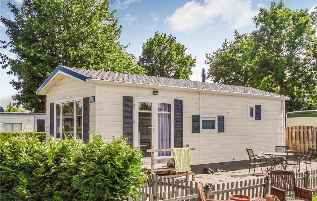 a small white tiny house with a patio at 2 Bedroom Gorgeous Home In Heinkenszand in Heinkensand