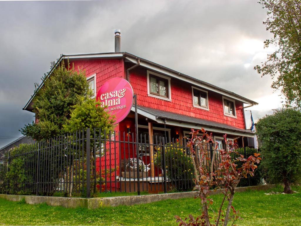 a red building with a sign on the side of it at Hotel Boutique Casa&Alma in Puerto Varas