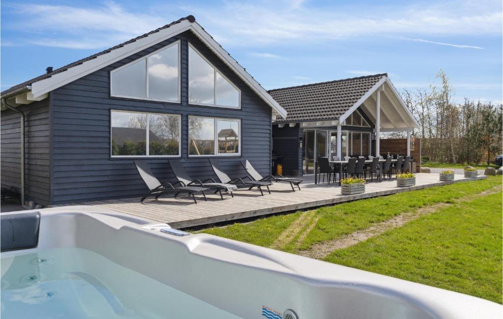 a house with a bath tub in front of it at Awesome Home In Idestrup With Sauna in Marielyst