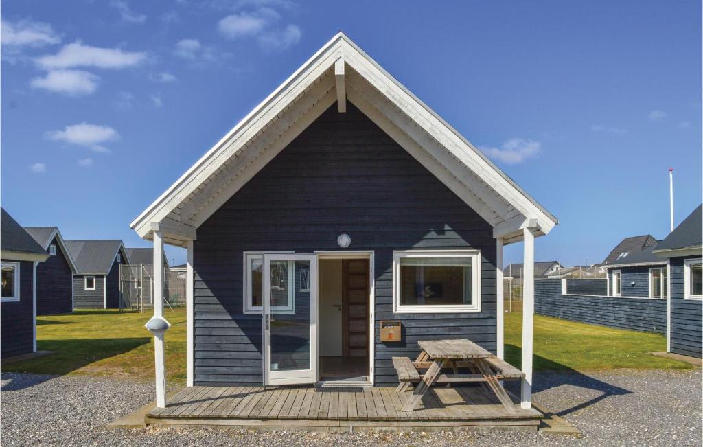 a small blue house with a picnic table and a bench at Hytte 17 in Thyborøn