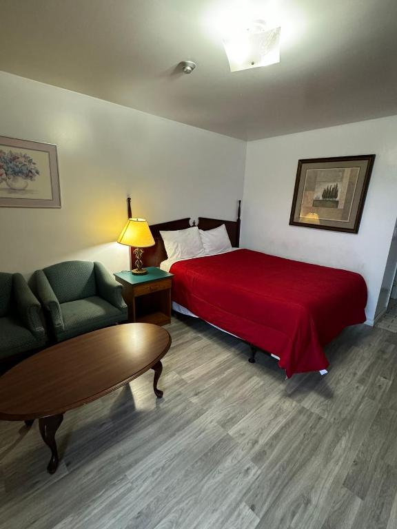 a hotel room with a bed and a couch and a table at 6267 Persepolis Inn in Niagara Falls