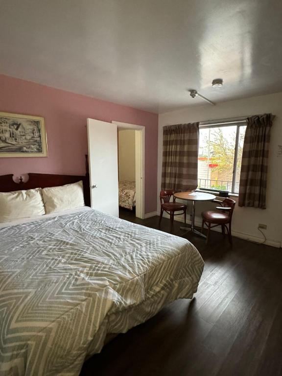 a hotel room with a bed and a table with chairs at 6267 Persepolis Inn in Niagara Falls