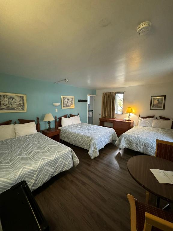 a hotel room with two beds and a table at 6267 Persepolis Inn in Niagara Falls