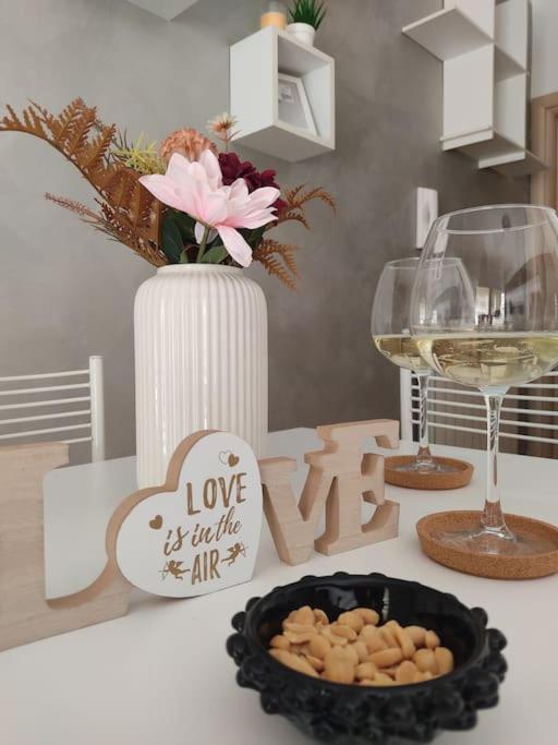 a table with a glass of wine and a plate of food at ross house in Fiumicino