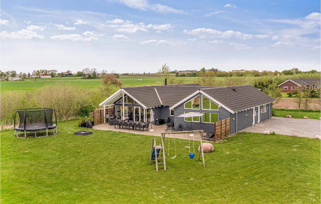 a backyard with a house and a playground at Awesome Home In Idestrup With Kitchen in Marielyst