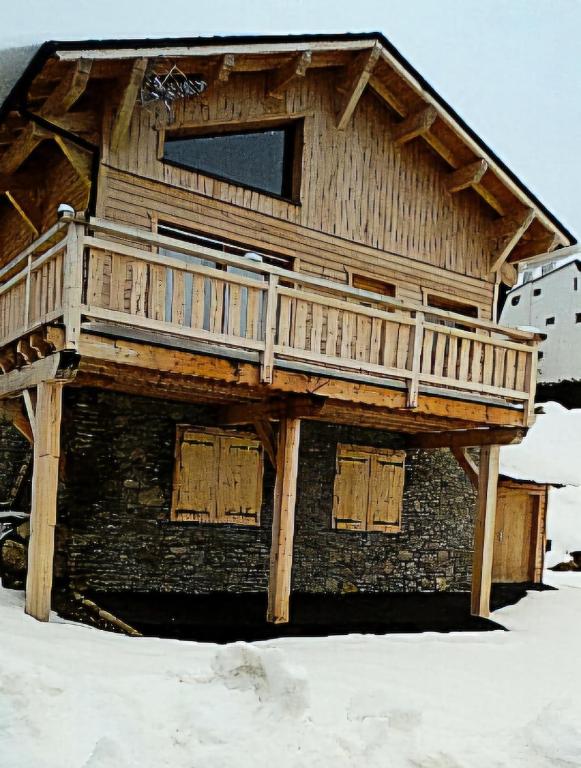une maison en bois avec une terrasse au sommet de la neige dans l'établissement L'El Cadi, à Font-Romeu