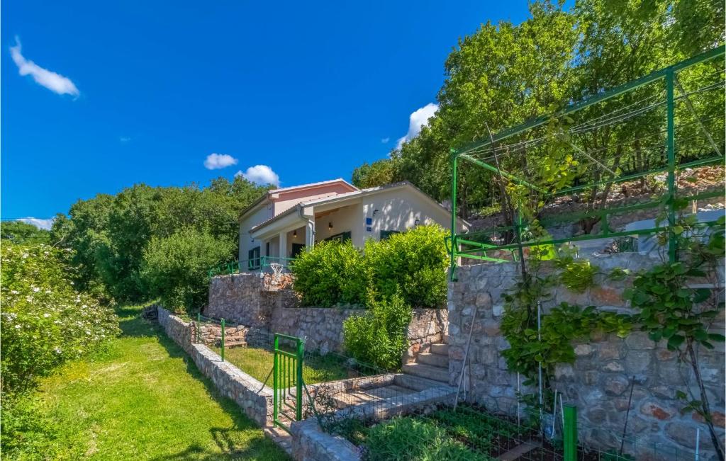 a house on a hill with a stone wall at 2 Bedroom Gorgeous Home In Klenovica in Klenovica