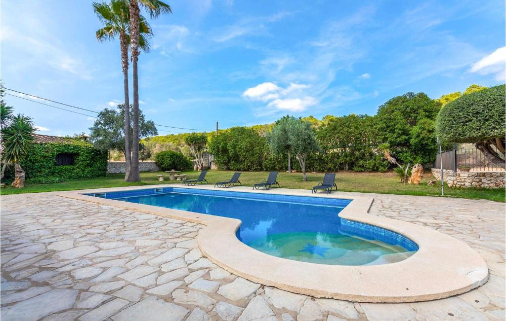 basen z 2 krzesłami i palmą w obiekcie Awesome Home In Sineu w mieście Sineu