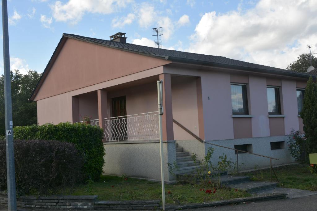 a small pink house with a porch and stairs at Maison individuelle à Issenheim in Issenheim