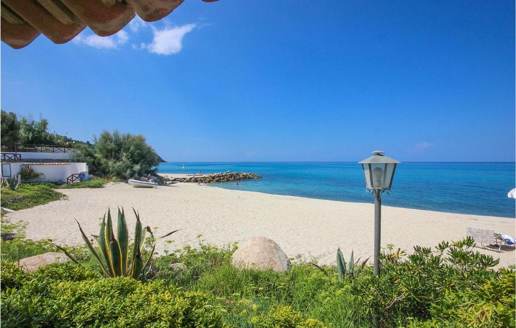 światło uliczne na piaszczystej plaży w pobliżu oceanu w obiekcie Pet Friendly Apartment In Ricadi w mieście Ricadi