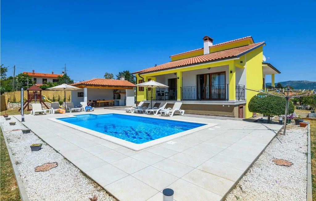 a villa with a swimming pool in front of a house at Santa Domenica in Rabac