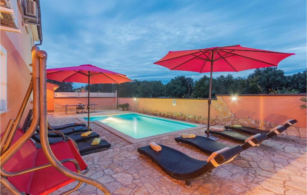 basen z parasolami i leżakami oraz basen w obiekcie Holiday Home Betiga Betiga Ii w mieście Barbariga
