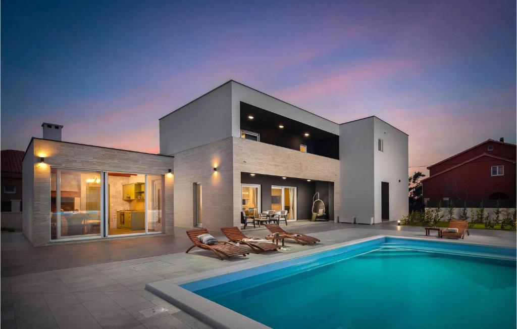 a house with a swimming pool in front of it at Villa Katarina Privlaka in Privlaka