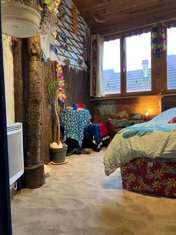 Postel nebo postele na pokoji v ubytování Chambre Océanie en Alsace