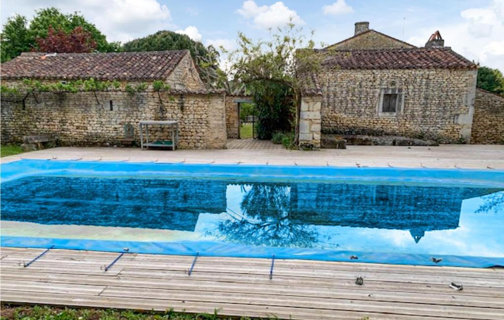 a large blue swimming pool in front of a building at Gorgeous Home In Geay in Geay