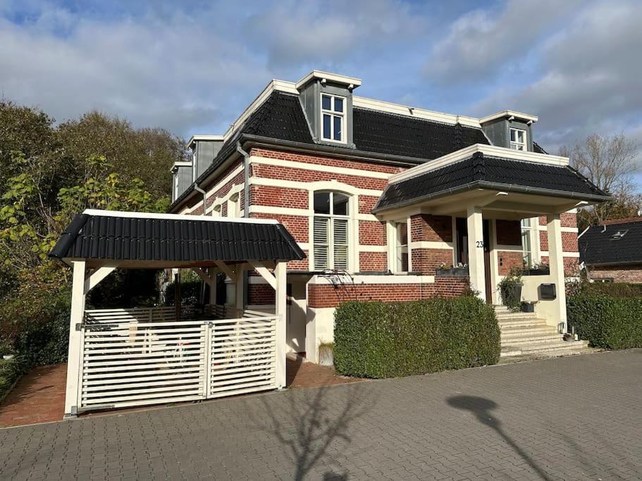 a red brick house with a white fence at Industriecultuur in Spechtholzhock