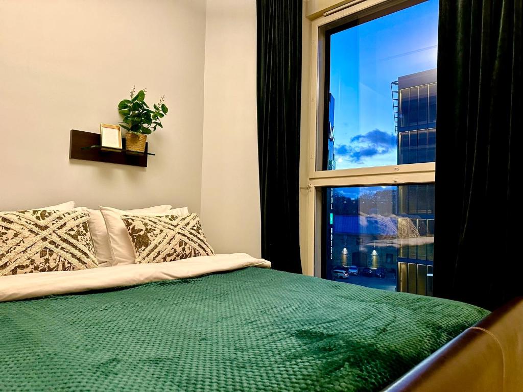 a bedroom with a green bed and a window at Luxury Suites Rotermanni by Rikas Hotels in Tallinn